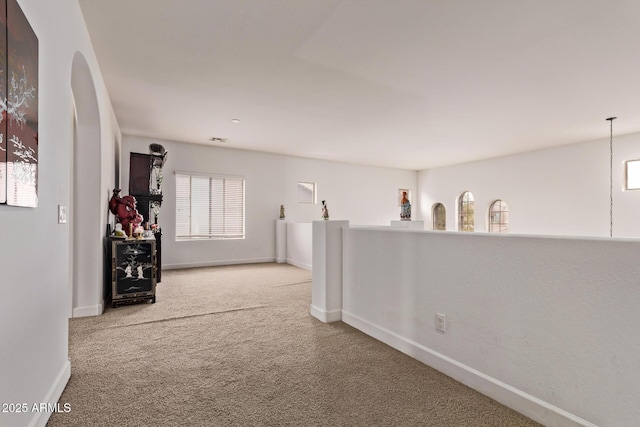 hallway featuring baseboards and carpet floors