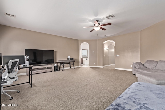 bedroom with carpet flooring, arched walkways, visible vents, and baseboards