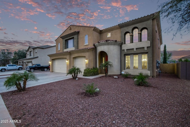 mediterranean / spanish home with fence, driveway, stucco siding, a garage, and a tile roof