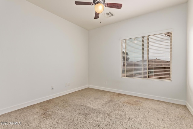 carpeted empty room with a ceiling fan, visible vents, and baseboards