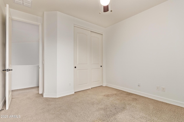 unfurnished bedroom with visible vents, a closet, carpet, baseboards, and ceiling fan