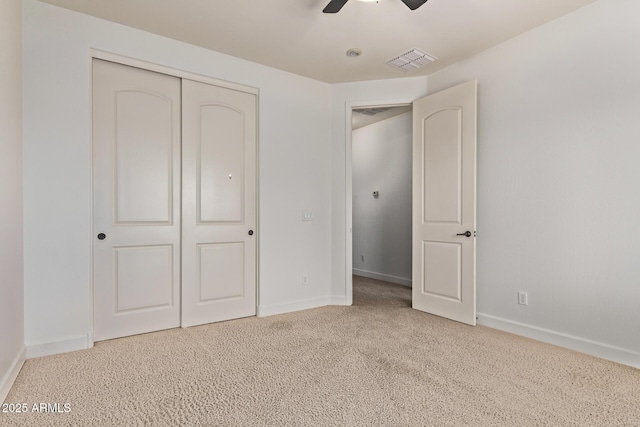 unfurnished bedroom featuring visible vents, a closet, carpet flooring, baseboards, and ceiling fan