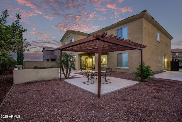 rear view of property featuring a patio, fence, a pergola, and stucco siding