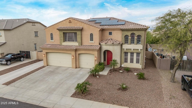 mediterranean / spanish home with fence, an attached garage, stucco siding, concrete driveway, and a tiled roof