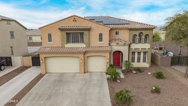 mediterranean / spanish house featuring fence, stucco siding, concrete driveway, a garage, and a tiled roof