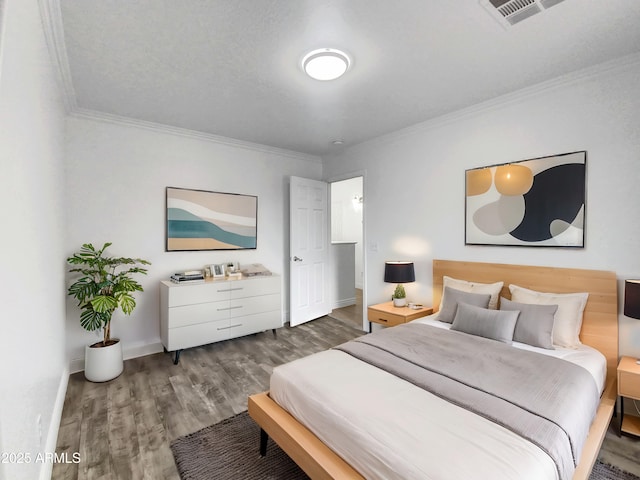 bedroom featuring ornamental molding, a textured ceiling, and dark hardwood / wood-style flooring