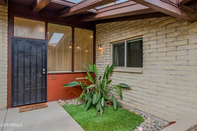 doorway to property featuring brick siding