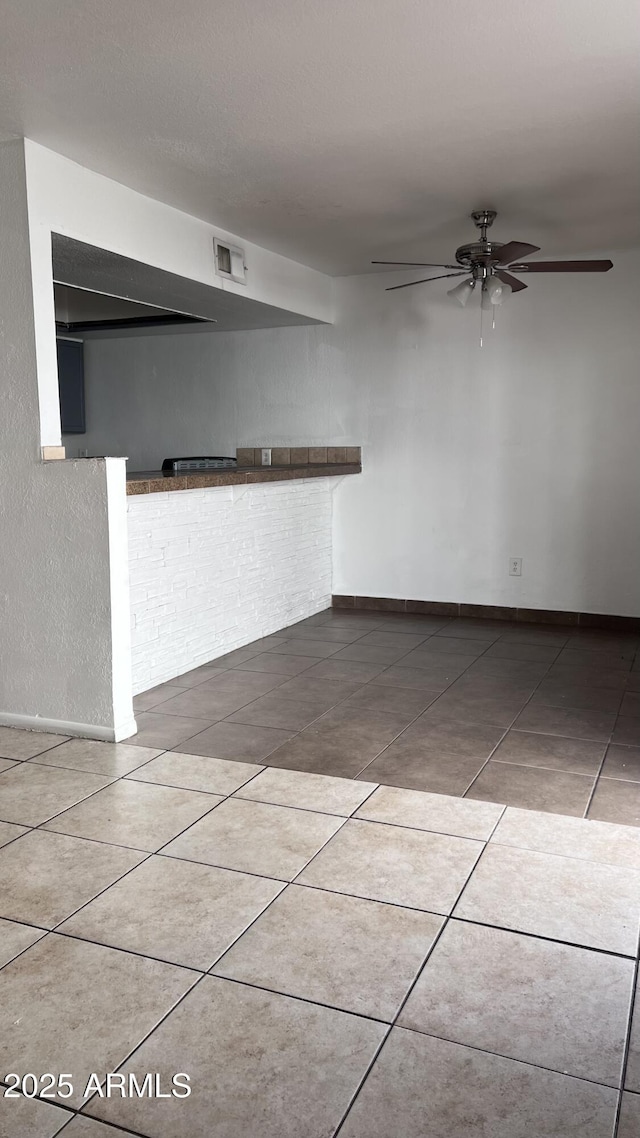 unfurnished room featuring ceiling fan and tile patterned floors