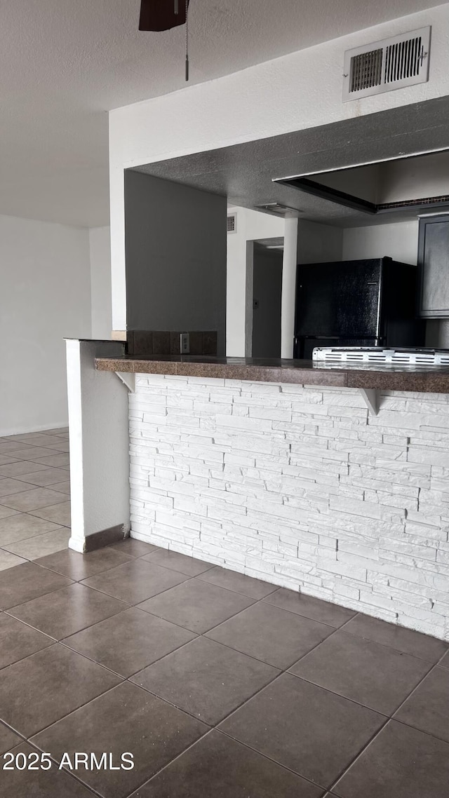 kitchen featuring dark tile patterned floors and a textured ceiling