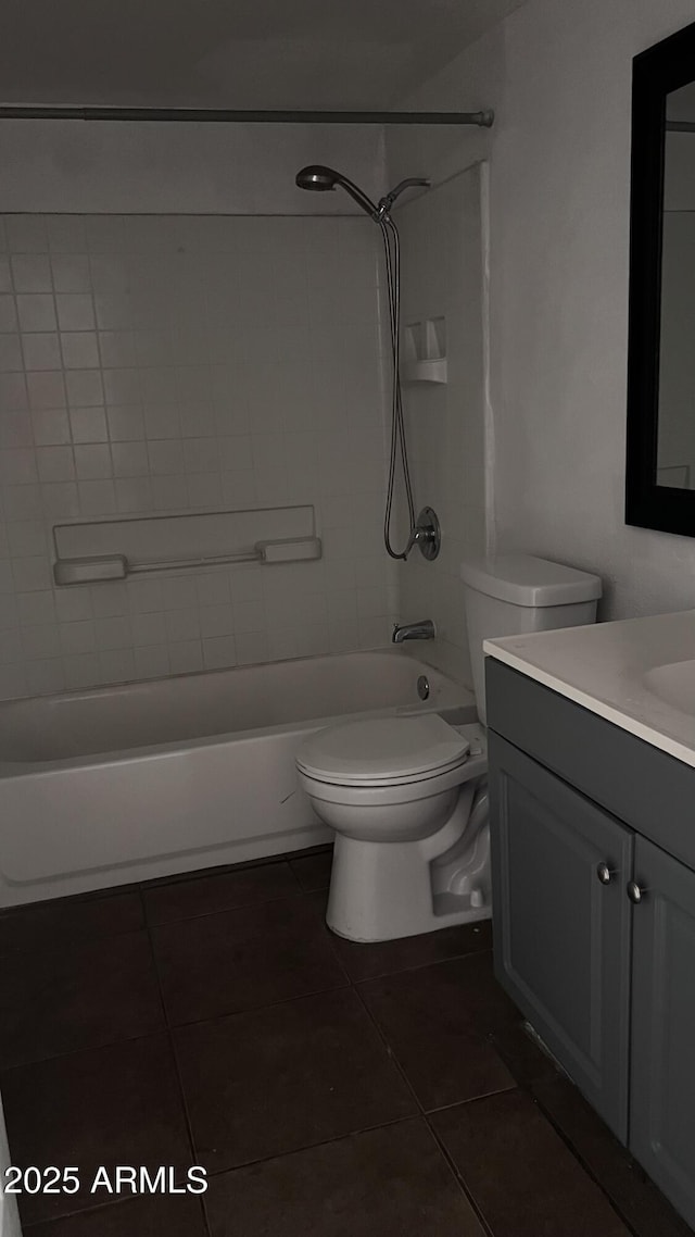 full bathroom featuring toilet, vanity, tiled shower / bath combo, and tile patterned floors