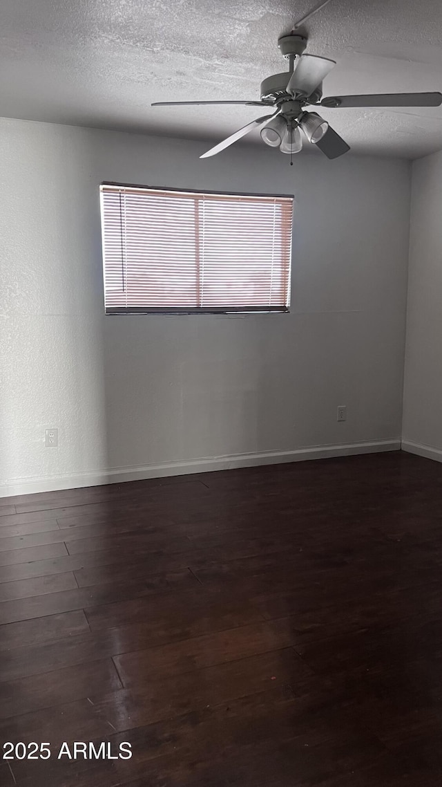 spare room featuring ceiling fan, a textured ceiling, and dark hardwood / wood-style flooring