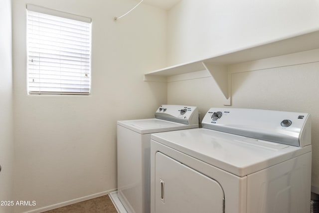 clothes washing area with washer and dryer, baseboards, and laundry area