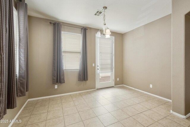 unfurnished room with baseboards, an inviting chandelier, visible vents, and light tile patterned floors