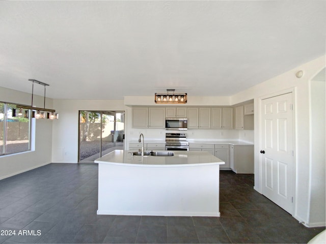 kitchen with sink, stainless steel appliances, decorative light fixtures, gray cabinets, and a center island with sink