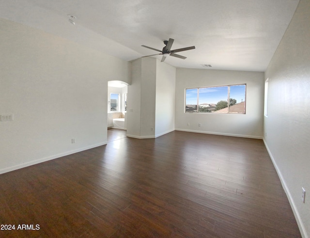 empty room with dark wood-type flooring, ceiling fan, and lofted ceiling