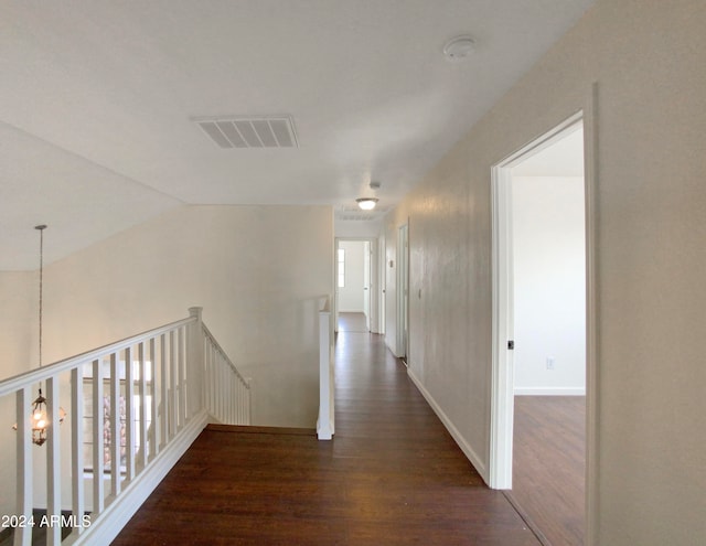 hallway featuring vaulted ceiling and dark hardwood / wood-style floors