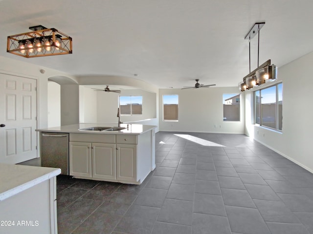 kitchen featuring white cabinetry, stainless steel dishwasher, dark tile patterned floors, and sink