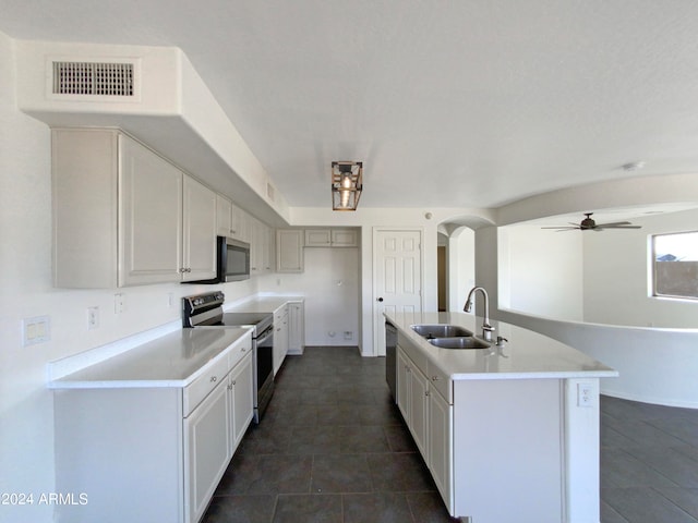 kitchen featuring sink, appliances with stainless steel finishes, an island with sink, and ceiling fan