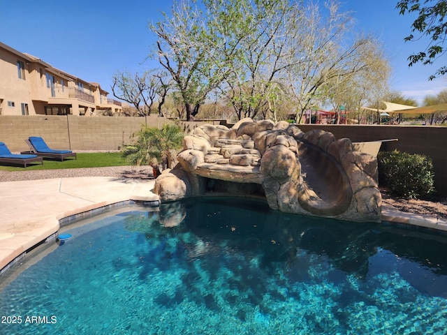 view of swimming pool with a patio and fence