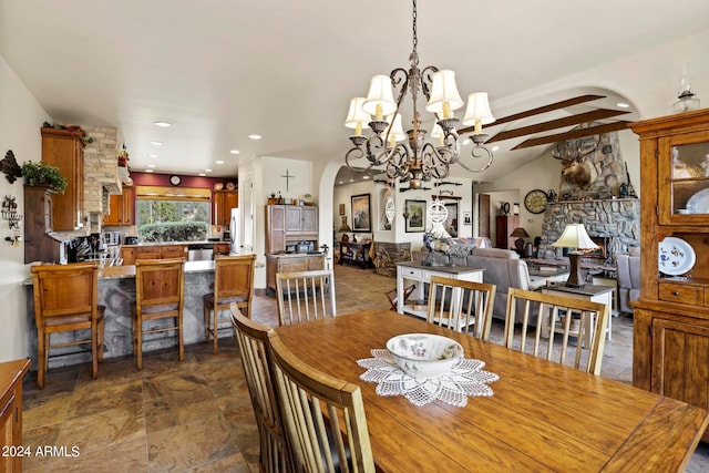 dining space with an inviting chandelier and beam ceiling