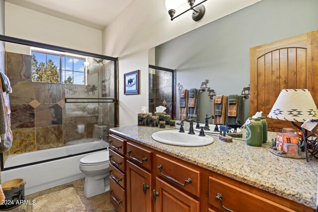 full bathroom with vanity, toilet, and bath / shower combo with glass door