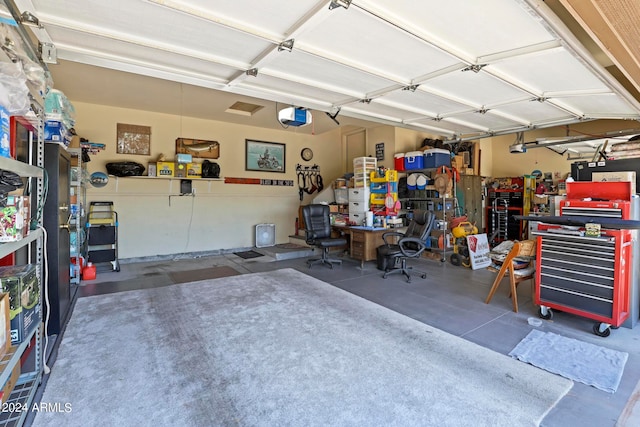 garage with a garage door opener and a workshop area