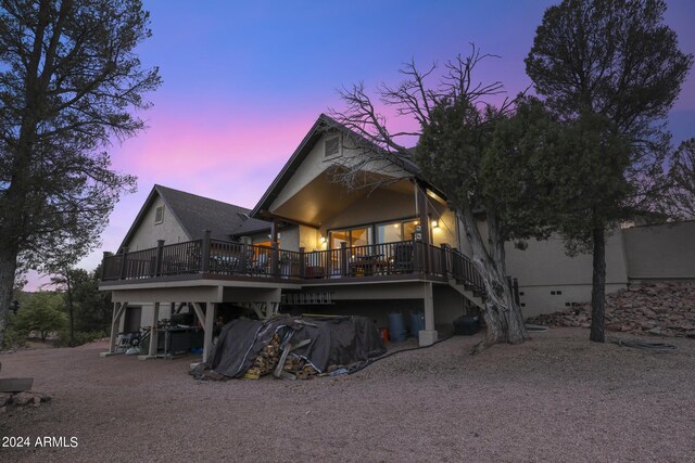 back house at dusk with a deck