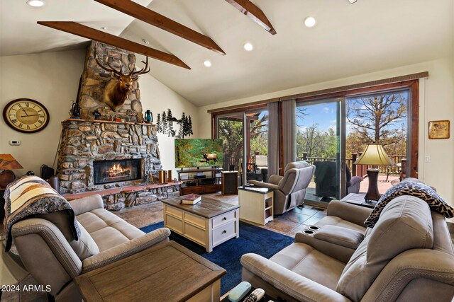 living room with beamed ceiling, high vaulted ceiling, ceiling fan, and a stone fireplace