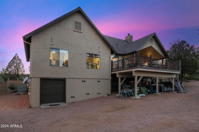 back house at dusk featuring a deck