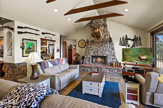 living room with vaulted ceiling with beams, ceiling fan, and a stone fireplace