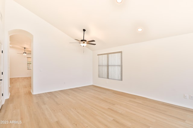 empty room with ceiling fan, lofted ceiling, and light hardwood / wood-style flooring