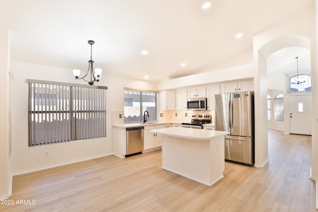 kitchen featuring tasteful backsplash, a center island, pendant lighting, an inviting chandelier, and stainless steel appliances