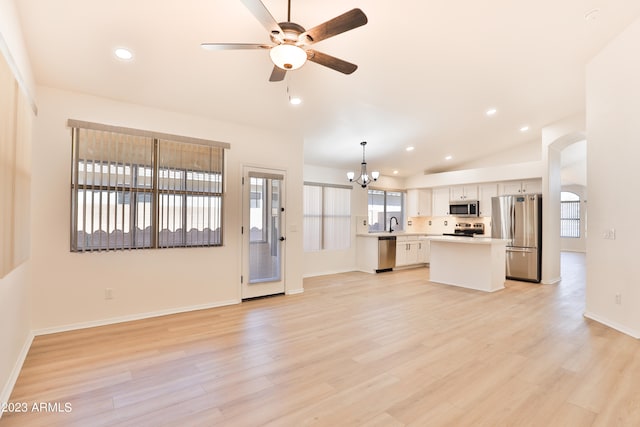 unfurnished living room with lofted ceiling, sink, ceiling fan with notable chandelier, and light hardwood / wood-style floors