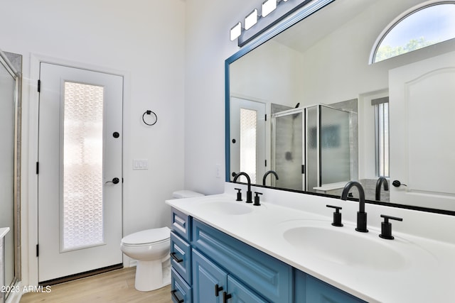 bathroom with toilet, vanity, vaulted ceiling, hardwood / wood-style floors, and an enclosed shower