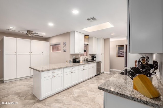 kitchen with white cabinets, ceiling fan, light stone countertops, and kitchen peninsula