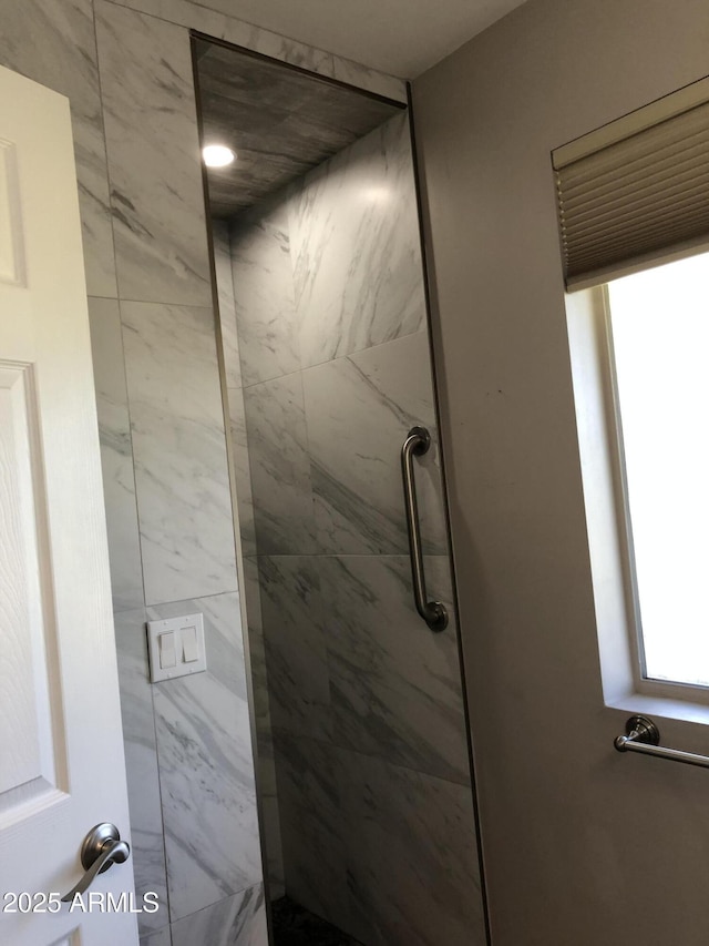 interior details featuring tiled shower