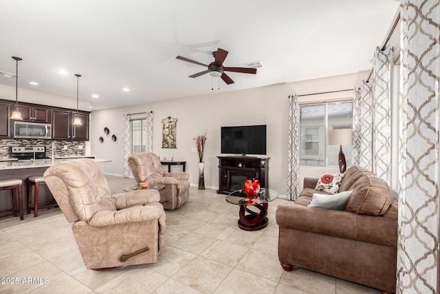 tiled living room featuring ceiling fan and a healthy amount of sunlight