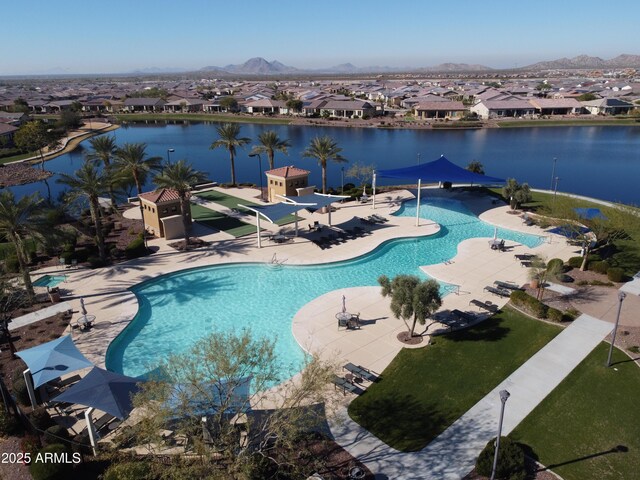 view of swimming pool with a patio area and a water and mountain view