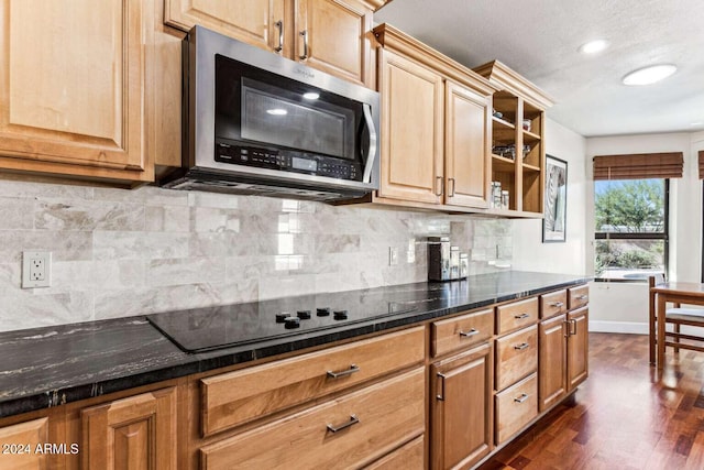 kitchen with dark stone countertops, black stovetop, decorative backsplash, and dark hardwood / wood-style floors