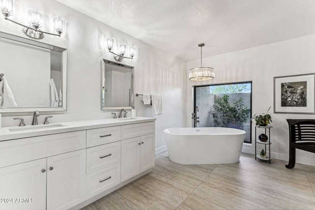 bathroom with vanity, wood-type flooring, a textured ceiling, and a bath