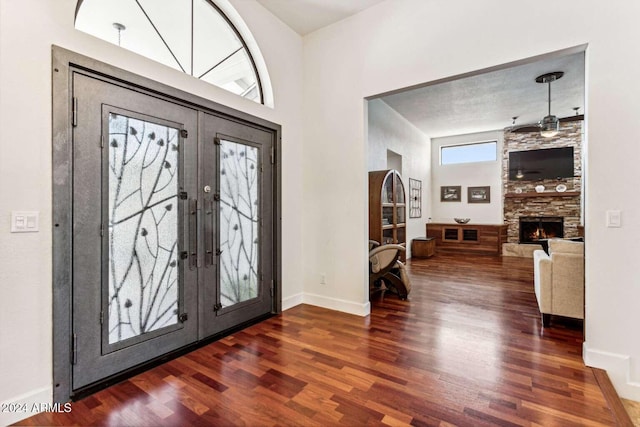 entryway with french doors, dark hardwood / wood-style flooring, and a fireplace