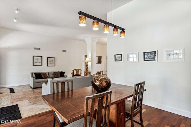 dining space with light hardwood / wood-style floors and decorative columns