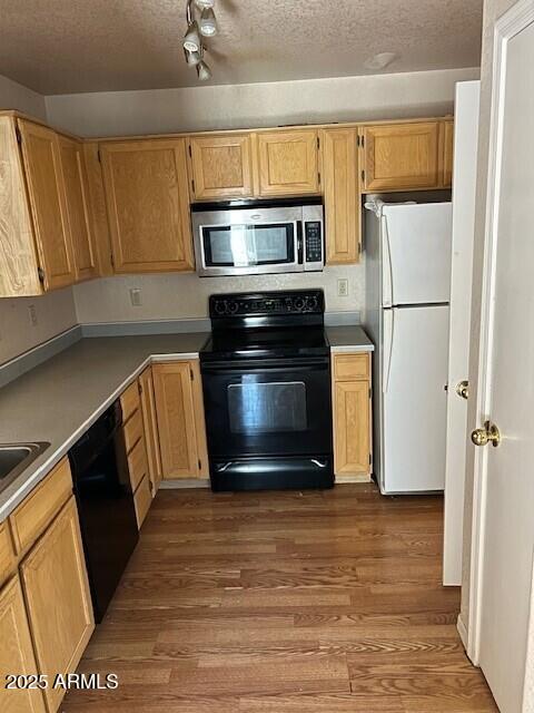 15088 N 85th Dr, Peoria, AZ 85381 - kitchen featuring black appliances, wood finished floors, a textured ceiling, and light brown cabinets