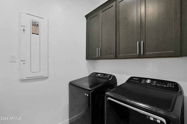 clothes washing area with cabinets, independent washer and dryer, and electric panel