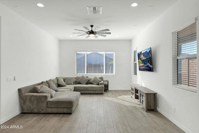 living room with light hardwood / wood-style floors and ceiling fan