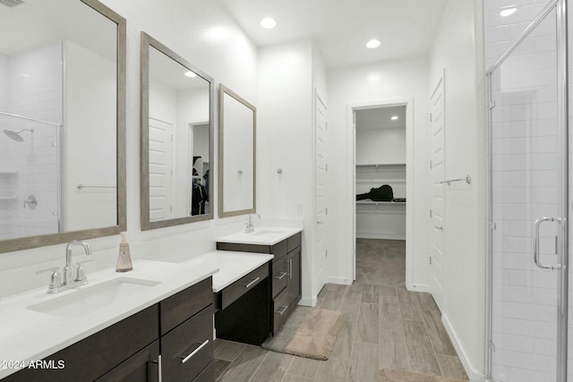 bathroom with vanity and a shower with door