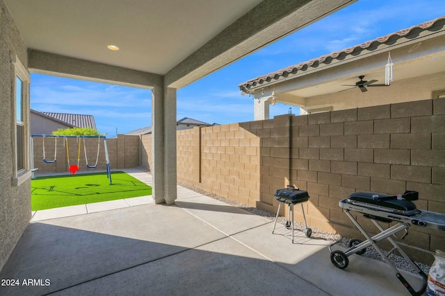 view of patio / terrace with ceiling fan, a playground, and grilling area