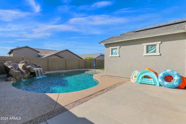 view of swimming pool with pool water feature and a patio