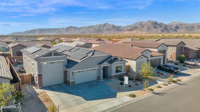 view of front of property featuring a mountain view, a garage, and solar panels