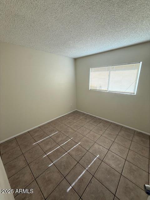 4625 W Thomas Rd Unit 48, Phoenix, AZ 85031 - spare room with tile patterned floors and a textured ceiling